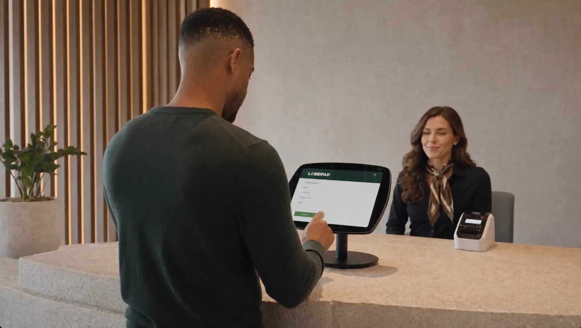 Visitor checking in on a Lobbipad iPad at a reception desk